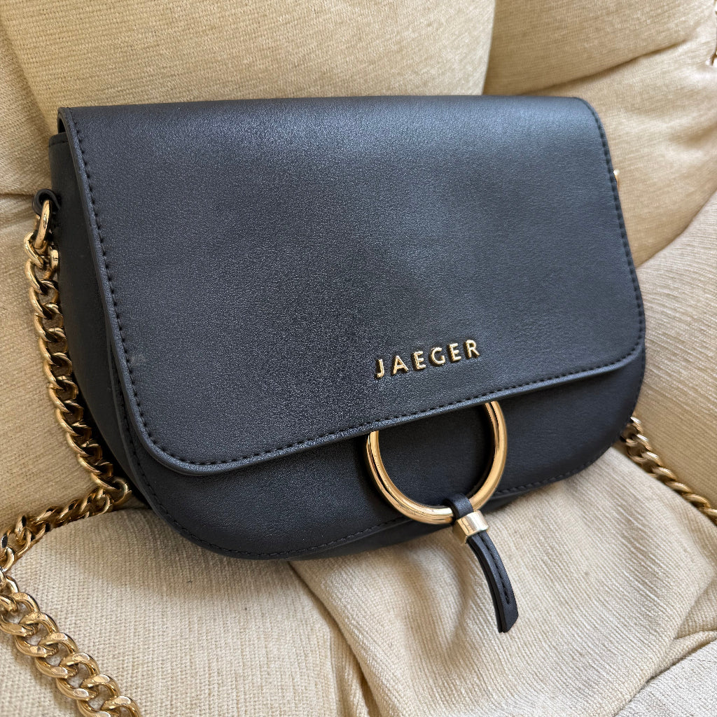 Jaeger black shoulder bag featuring a gold chain strap and a circular gold ring clasp