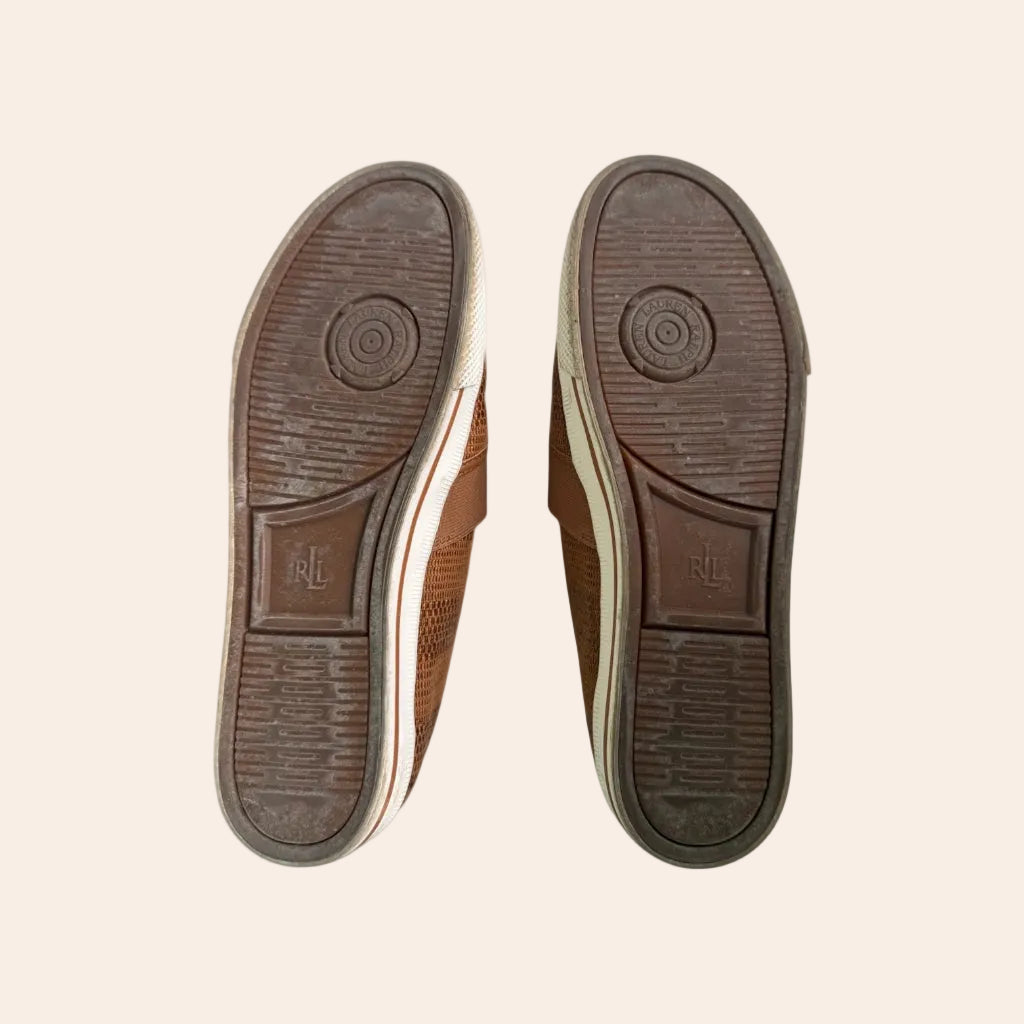 brown-leather-shoes-with-visible-brand-logo-on-a-beige-background

